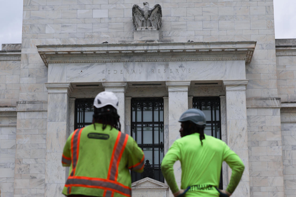 WASHINGTON, DC - JULY 26: Construction workers look on outside the Marriner S. Eccles Federal Reserve building on July 26, 2022 in Washington, DC. Officials with the Federal Open Market Committee (FOMC) are holding a two-day meeting as the Federal Reserve is expected to raise interest rates again this week to combat inflation. (Photo by Anna Moneymaker/Getty Images)