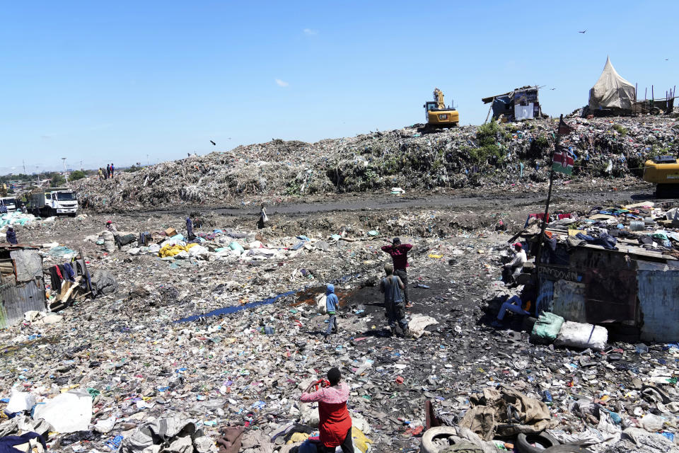 People scavenge recyclable materials for a living, at Dandora, the largest garbage dump in Nairobi, Kenya Monday, April 22, 2024. Students at a school next to Kenya's largest dumpsite are on a mission to try to purify the air with bamboo. They have planted more than 100 seedlings along the wall that separates the school from the trash dump that was declared full 23 years ago. (AP Photo/Brian Inganga)