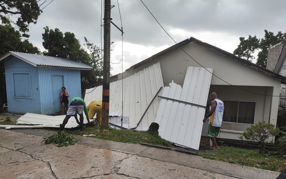 Men pick up a damaged roof in the aftermath of Hurricane Julia in San Andres island, Colombia, Sunday, Oct.9, 2022. Hurricane Julia hit Nicaragua’s central Caribbean coast on Sunday after lashing Colombia’s San Andres island, and a weakened storm was expected to emerge over the Pacific. (AP Photo/Daniel Parra)