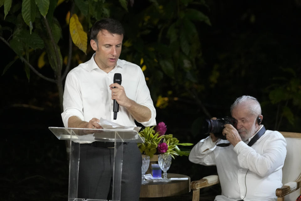 French President Emmanuel Macron, left, speaks as Brazil's President Luiz Inacio Lula da Silva takes photos, during a ceremony on the Combu Island, near Belem, Para state, Brazil, Tuesday, March 26, 2024. (AP Photo/Eraldo Peres)