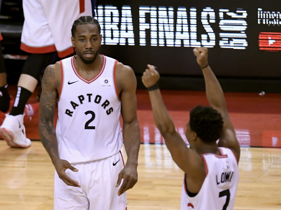 Toronto Raptors' Kawhi Leonard (2) and Kyle Lowry (7) react during the second half of Game 6 of the team's NBA basketball playoffs Eastern Conference finals against the Milwaukee Bucks on Saturday, May 25, 2019, in Toronto. The Raptors won 100-94 to advance to the NBA Finals. (Frank Gunn/The Canadian Press via AP)