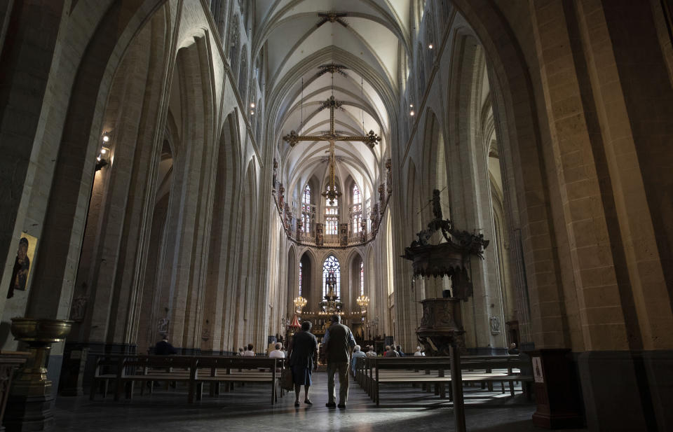 In this photo taken on Wednesday, June 24, 2020, people gather prior to a funeral at the Saint Martin Basilica in Halle, Belgium. In Halle, a small trading town of 40,000, as across much of Europe, the tide is turning and a new consciousness is taking shape in the wake of the Black Lives Matter movement in the United States. (AP Photo/Virginia Mayo)