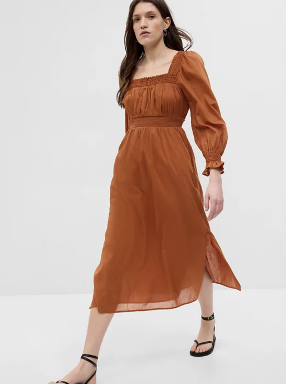 brunette model wearing long sleeve brown midi dress, Puff Sleeve Smocked Maxi Dress in Rust Brown (Photo via Gap)