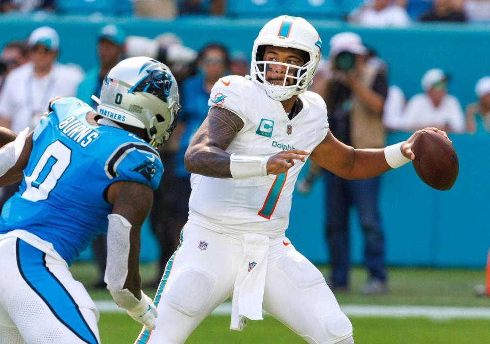 Miami Dolphins quarterback Tua Tagovailoa (1) sets up to pass as Carolina Panthers linebacker Brian Burns (0) defends during third quarter of an NFL football game at Hard Rock Stadium on Sunday, Oct. 15, 2023 in Miami Gardens, Fl.