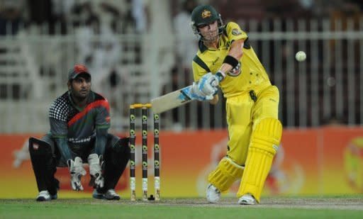 Australian captain Michael Clarke (R) hits a six as Afghanistan's wicketkeeper Mohammad Shehzad looks on during a One Day International cricket match at the Sharjah cricket stadium. Australia beat Afghanistan by 66 runs in the first-ever limited over international between the two countries at Sharjah Stadium