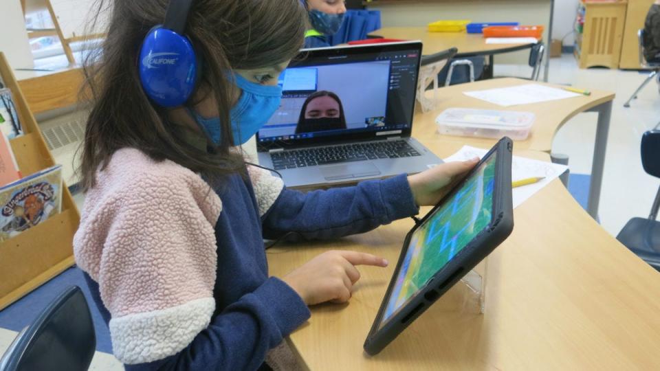 Kindergarten student Meadow Mikael takes part in the districtwide coding event, with the help of 12th grader Zoe Boyd via video chat.