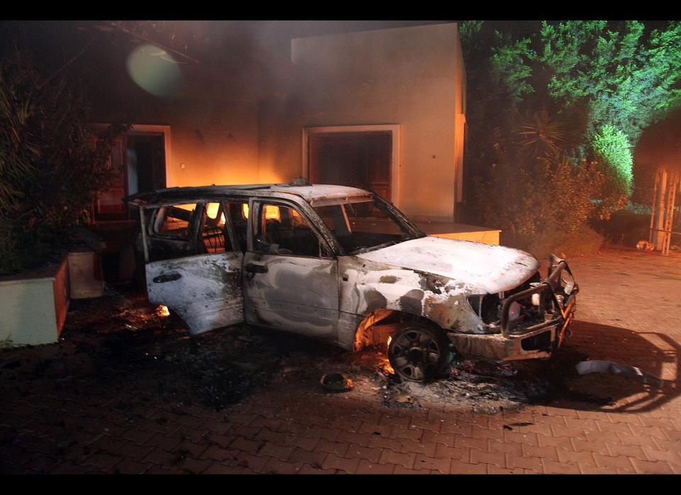 A vehicle and surrounding buildings smolder after they were set on fire inside the US consulate compound in Benghazi, late on September 11, 2012. (STR/AFP/GettyImages)