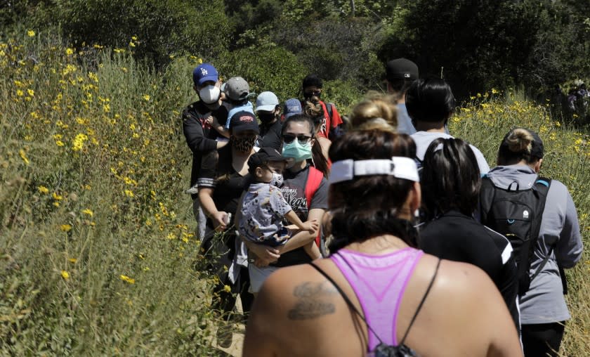 PASADENA, CA - MAY 24: Visitors share a narrow hiking path at Eaton Canyon Natural Area Park on Sunday, May 24, 2020 in Pasadena, CA during the Memorial Day weekend. Signage and park volunteers reminded visitors to wear masks. (Myung J. Chun / Los Angeles Times)