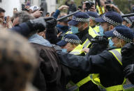 Riot police face protesters who took part in a 'We Do Not Consent' rally at Trafalgar Square, organised by Stop New Normal, to protest against coronavirus restrictions, in London, Saturday, Sept. 26, 2020. (AP Photo/Frank Augstein)