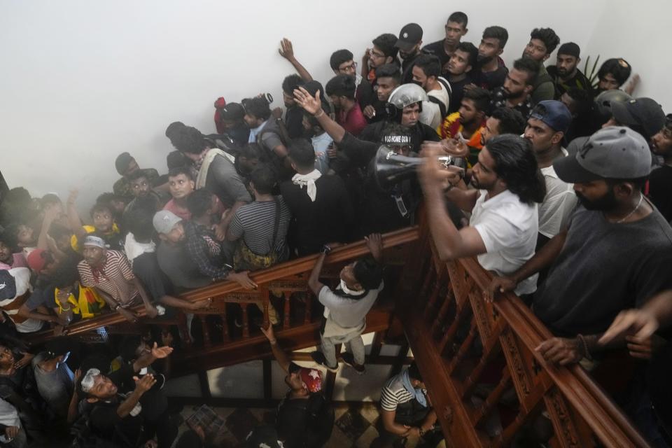 Protesters climb the stairs after storming Sri Lankan Prime Minister Ranil Wickremesinghe's office, demanding he resign after president Gotabaya Rajapaksa fled the country amid economic crisis in Colombo, Sri Lanka, July 13, 2022. The image was part of a series of images by Associated Press photographers that was a finalist for the 2023 Pulitzer Prize for Breaking News Photography. (AP Photo/Rafiq Maqbool)