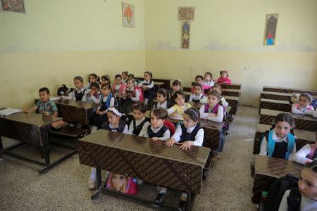 Pupils attend a class at an elementary school in eastern Mosul, Iraq, April 17, 2017. REUTERS/Marko Djurica