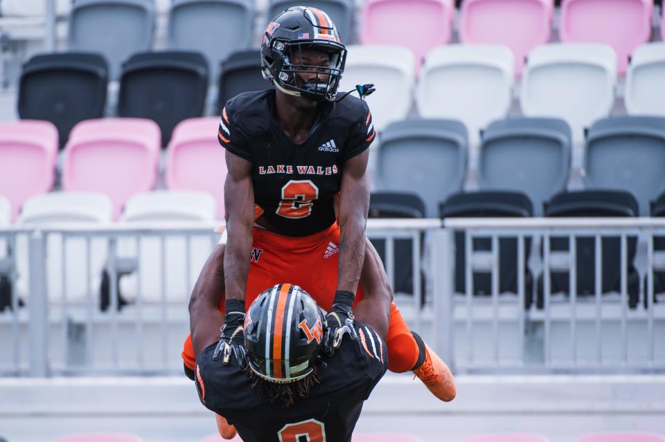 Lake Wales defensive end Terrell James (9) lifts Lake Wales wide receiver Carlos Mitchell (2) in celebration of Mitchell's second quarter touchdown during the Class 3S football state championship game between Lake Wales and Mainland at DRV PNK Stadium on Friday, December 16, 2022, in Fort Lauderdale, FL.