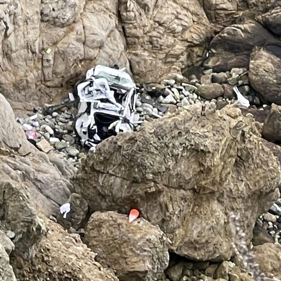 This image from video provided by San Mateo County Sheriff's Office shows a Tesla vehicle that plunged off a Northern California cliff along the Pacific Coast Highway, Monday, Jan. 2, 2023, near an area known as Devil's Slide, leaving four people in critical condition, a fire official said. The vehicle fell about 250 feet (76.20 meters) from the highway, the fire official said. Motorists were told to expect delays as rescuers worked. Helicopters were expected to transport four people to hospitals. (San Mateo County Sheriff's Office via AP)