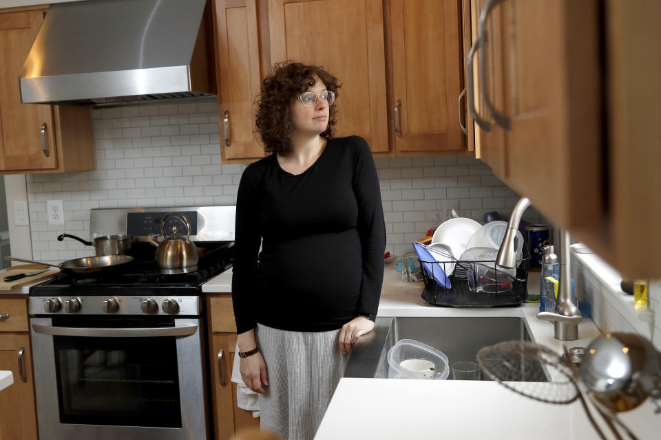 In this Wednesday, Feb. 12, 2020, Diana Betz, an assistant professor of psychology at Loyola University Maryland, poses at her home in Crofton, Md. Betz said, deciding who will fill out the questionnaire in the 2020 Census may force spouses or domestic partners to have conversations about their power dynamics that they might not have had for 10 years, the last time there was a decennial census. (AP Photo/Julio Cortez)