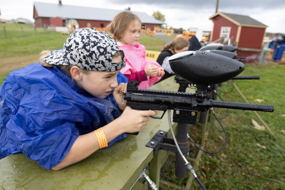 Brother and sister Kole, 13, and Maezi Bohland, 7, try their hand at paintball guns at Nickajack Farms in Lawrence Township.