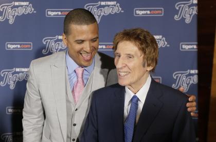 Victor Martinez (L) shares a laugh with Mike Ilitch after agreeing to terms on a new deal in 2014. (AP)
