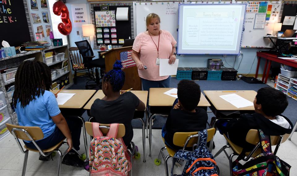 Dodson Elementary School teacher Melissa Kurras explains an English language arts assignment to third grade students Tuesday, June 6, 2023, in Nashville, Tenn. The students are part of Promising Scholars, the Metro Nashville Public Schools summer program. A legislative working group meeting next week is studying whether the state can reject federal education funding.