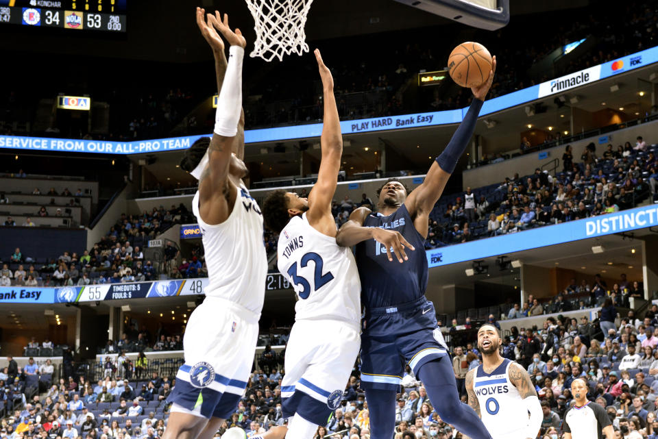 Memphis Grizzlies forward Jaren Jackson Jr. (13) shoots against Minnesota Timberwolves center Karl-Anthony Towns (32) in the first half of an NBA basketball game Thursday, Jan. 13, 2022, in Memphis, Tenn. (AP Photo/Brandon Dill)