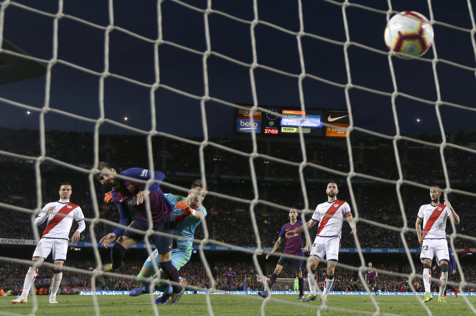 FC Barcelona's Gerard Pique, second left, heads for the ball to score his side's first goal during the Spanish La Liga soccer match between FC Barcelona and Rayo Vallecano at the Camp Nou stadium in Barcelona, Spain, Saturday, March 9, 2019. (AP Photo/Manu Fernandez)