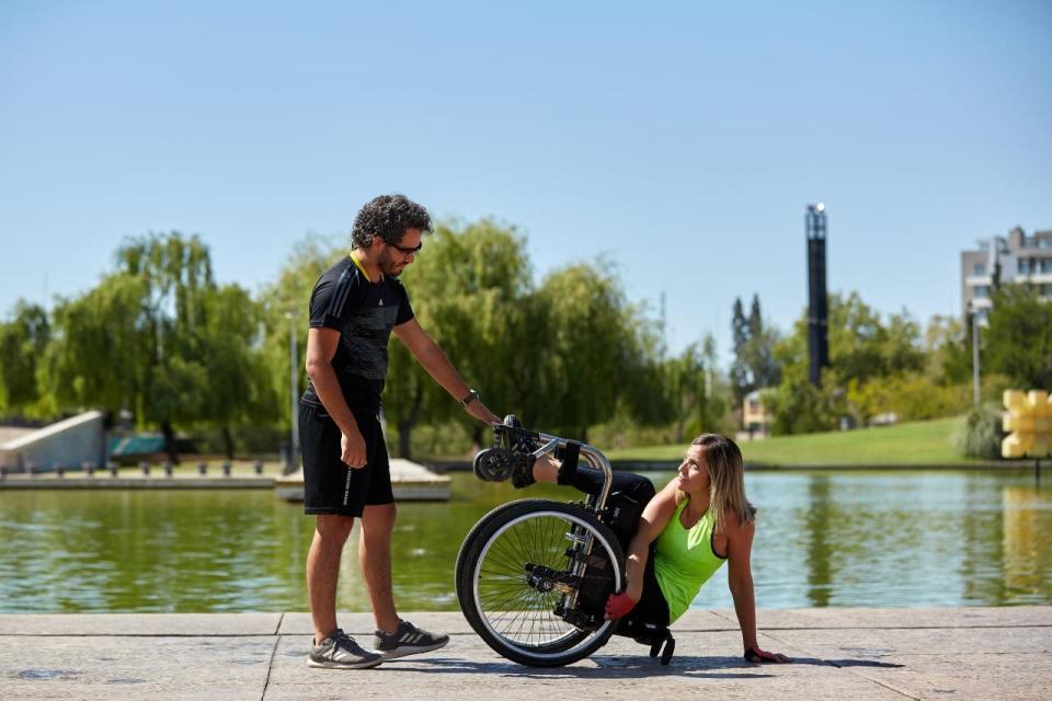 Natalia, licenciada en Sistemas de Información, junto a su entrenador, David Pérez, con quien impulsa el proyecto "Rompiendo barreras". Ya se animó a andar en bicicleta por la montaña mendocina y utiliza parques de la capital provincial para mostrar cómo se ejercita.