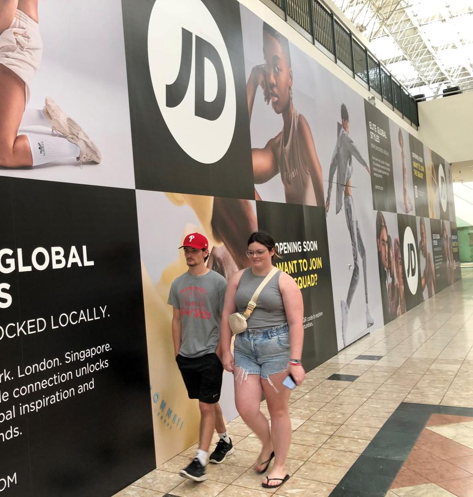 CJ McKenna (left) and Ryan Gack, both of Philadelphia, pass the location for the JD Sports store that should open in Oxford Valley Mall this fall. Gack was doing back-to-college shopping for her return to Holy Family University in the fall.