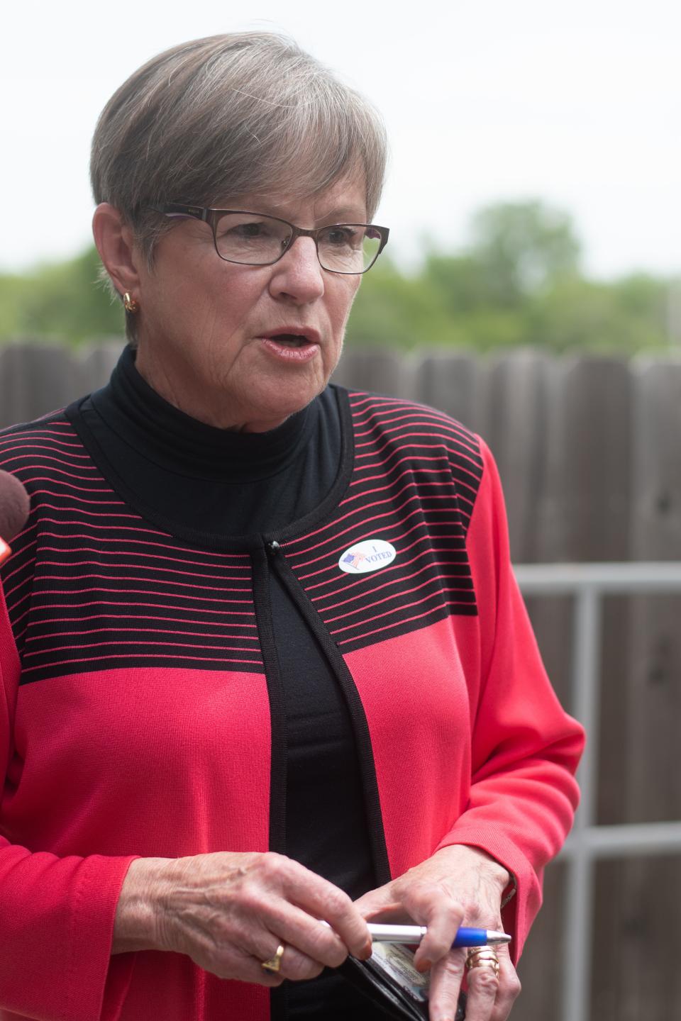 Gov. Laura Kelly answers questions from the media after she voted early in the primary elections at the Shawnee County Elections Office Friday.