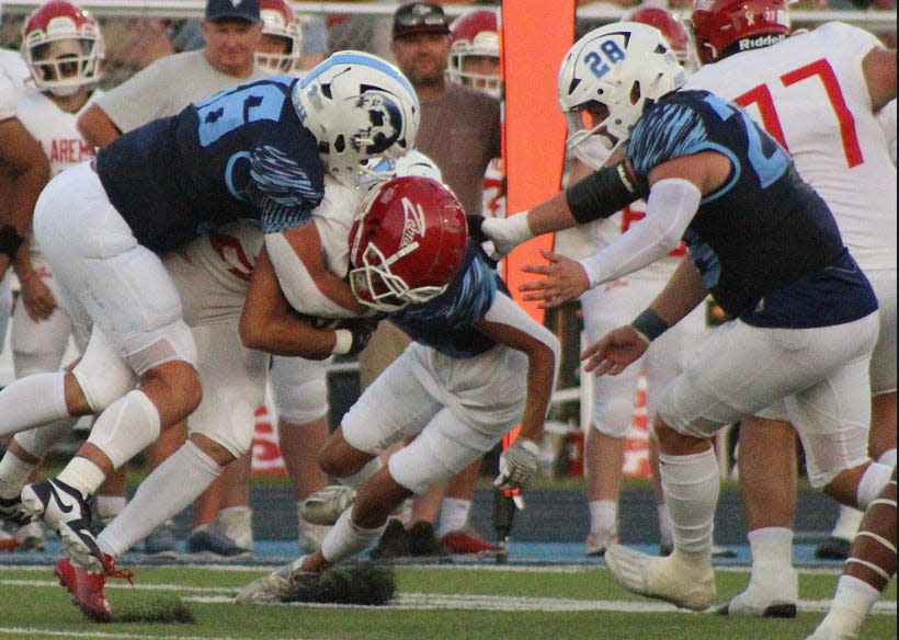 Bartlesville High School's Casey Young, right, helps bring down a player during football action against Claremore High School on Sept. 1, 2023.