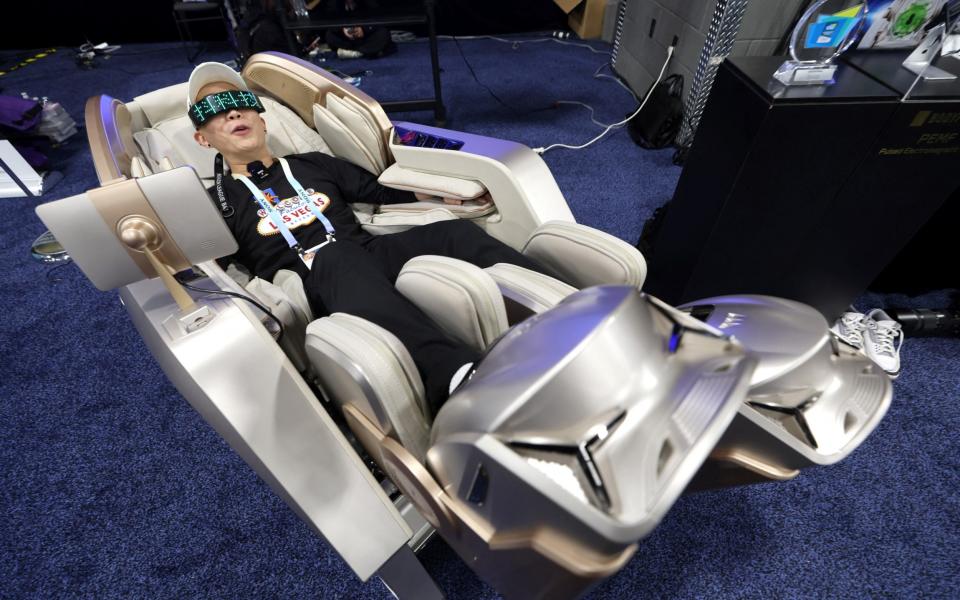 A CES 2024 visitor tries out a Phantom Neo massage chair