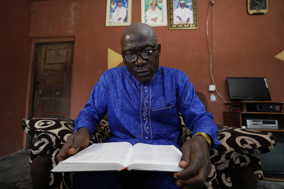 Patrick Aganyebi, a maintenance operator aboard the Trinity Spirit oil ship, reads from the Bible in his home in Igbokoda, Nigeria, on Tuesday, Sept. 6, 2022. Aganyebi says it was by the grace of God that he and two fellow crewmen escaped that night from the Trinity Spirit, a rusting ship anchored 15 miles (24 kilometers) off the coast of Nigeria that pulled crude oil from the ocean floor. (AP Photo/Sunday Alamba)