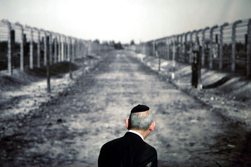 Le rabbin Israel Singer, président du Congrès juif mondial, regarde une photo montrant un couloir du camp de concentration d'Auschwitz