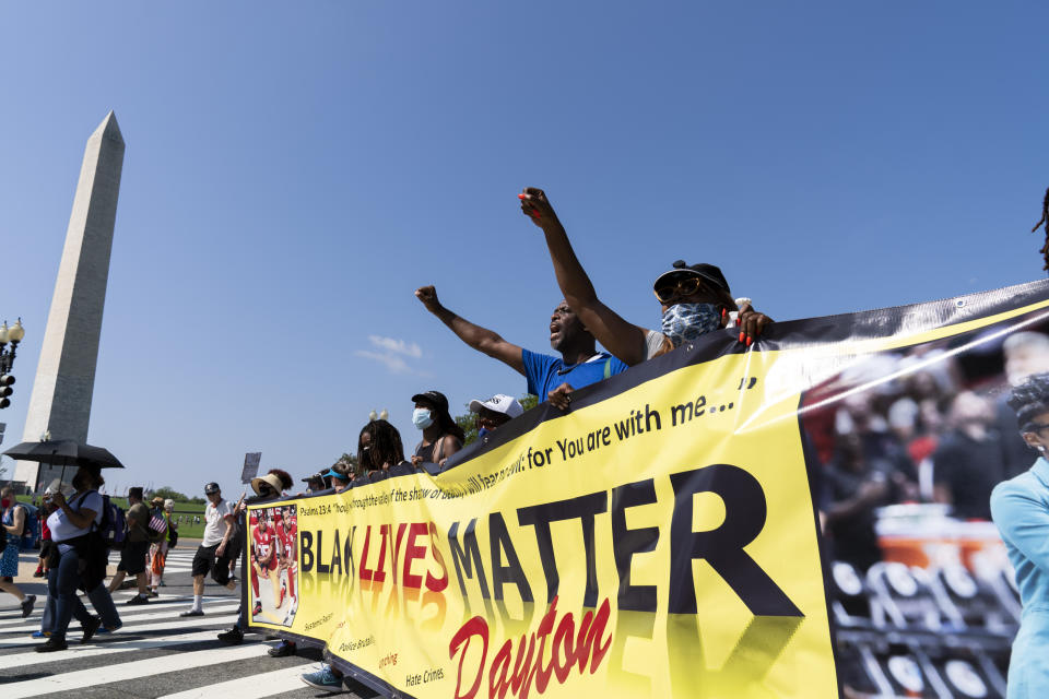 FILE - With the Washington Monument at left, demonstrators hold up banners during a march for voting rights commeorating the 58th anniversary of the March on Washington, Saturday, Aug. 28, 2021, in Washington. Hundreds of thousands of voting rights advocates rallied across the country Saturday to call for sweeping protections against a further erosion of the Voting Rights Act of 1965. (AP Photo/Jose Luis Magana, File)