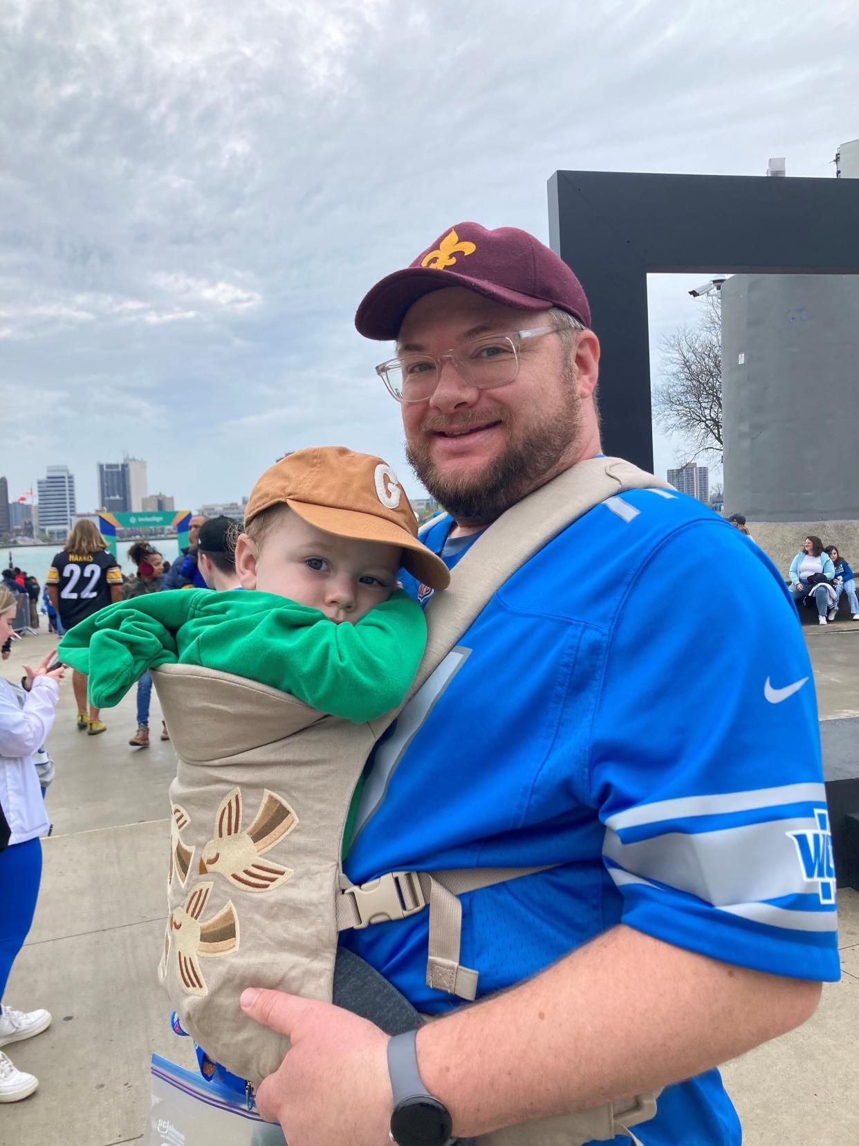 Carl Hall of Detroit and his nearly 2-year-old son, Gus, navigated the crowd near Hart Plaza in downtown on Day 3 of the NFL Draft Saturday, April 27, 2024.