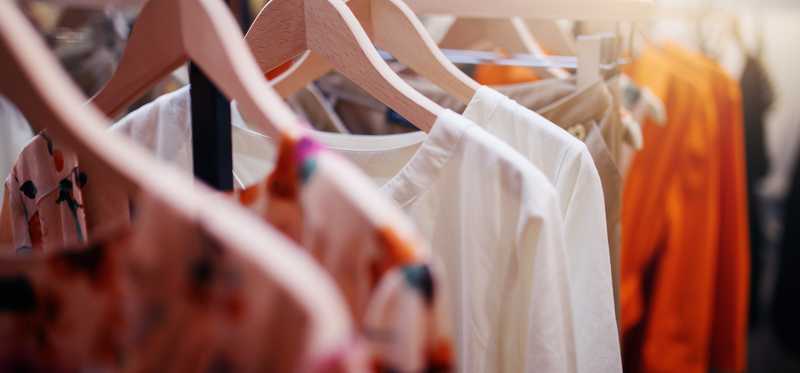 Women's blouses are displayed on a store rack.