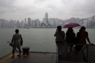 People rest by the waterfront of Tsim Sha Tsui shopping district hours before Typhoon Usagi is expected to make landfall, in Hong Kong September 22, 2013. Hong Kong was bracing on Sunday for this year's most powerful typhoon, with government meteorologists warning of severe flooding created by a double whammy of powerful winds and exceptionally high tides. REUTERS/Tyrone Siu (CHINA - Tags: BUSINESS ENVIRONMENT)