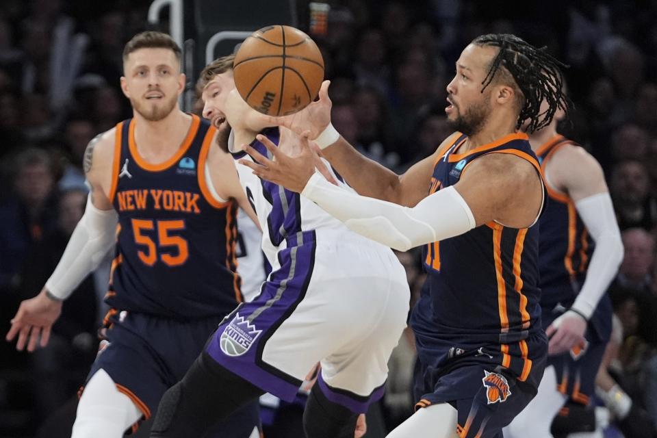 New York Knicks' Jalen Brunson, right, steals the ball from Sacramento Kings' Domantas Sabonis during the first half of an NBA basketball game Thursday, April 4, 2024, in New York. (AP Photo/Frank Franklin II)