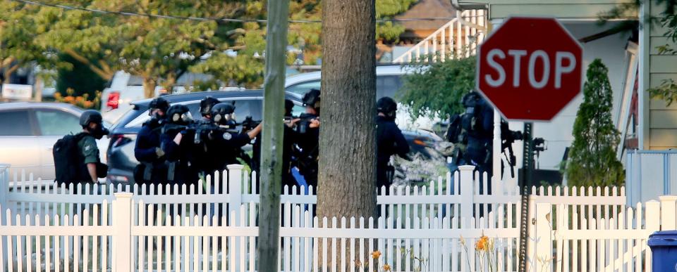 SWAT officers make their final push into a Ravenwood Drive home Friday afternoon where Maxwell Johnston had kept them at bay. Johnston is the suspect in the slaying of Gabriella Caroleo in Manchester.