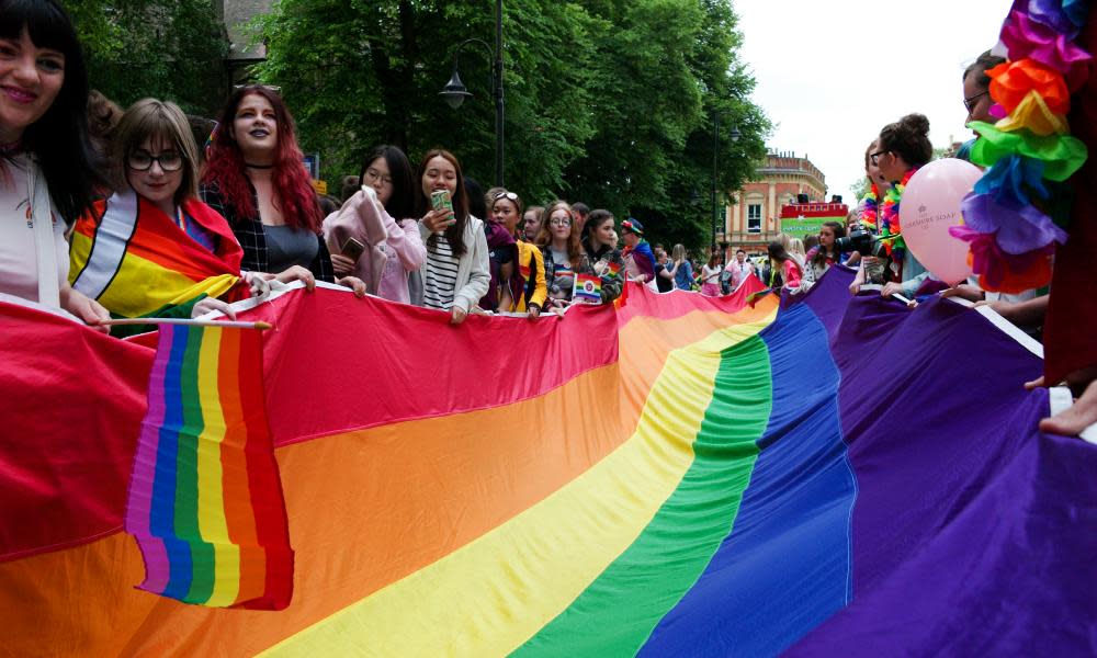 People hold a rainbow flag during the 2018 Pride parade in York