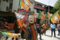 A supporters of India's ruling Bharatiya Janata Party wears mask of Indian Prime Minister Narendra Modi as he celebrates early trends of party's victory in general elections in Ahmadabad, India, Thursday, May 23, 2019. Modi and his party were off to an early lead as vote counting began Thursday following the conclusion of the country's 6-week-long general election, sending the stock market soaring in anticipation of another five-year term for the Hindu nationalist leader. (AP Photo/Ajit Solanki)