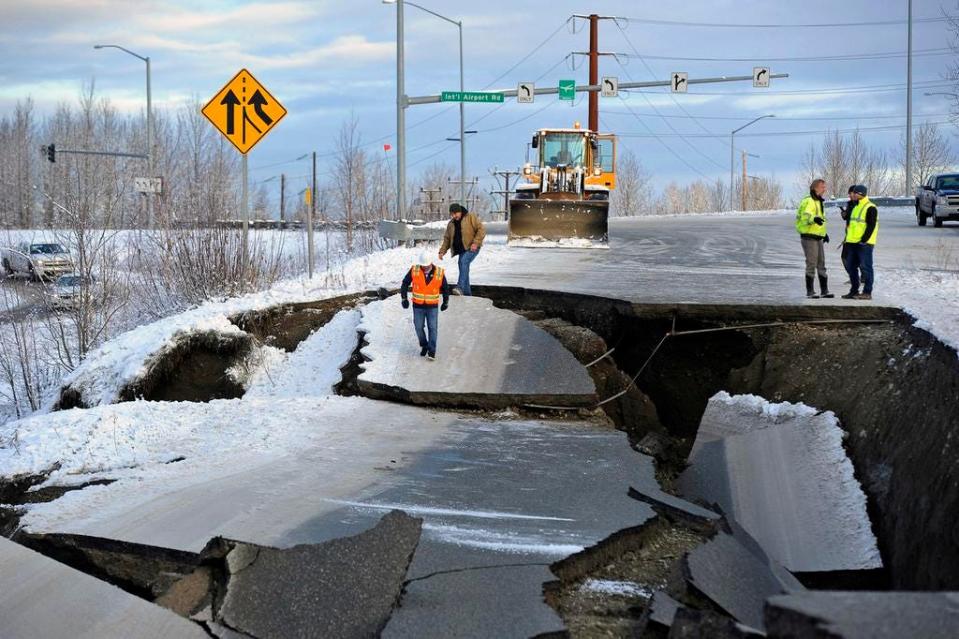 Workers inspect a road Nov. 30, 2018, that collapsed during an earthquake in Anchorage, Alaska.