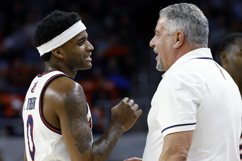 Auburn guard K.D. Johnson (0) talks with coach Bruce Pearl during the first half of the team's NCAA college basketball game against Penn on Tuesday, Jan. 2, 2024, in Auburn, Ala. (AP Photo/Butch Dill)