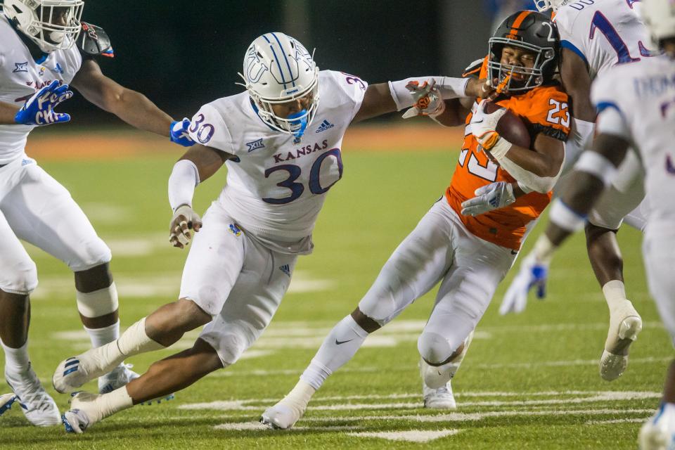 Kansas linebacker Rich Miller (30) tackles Oklahoma State running back Jaden Nixon (23) during an Oct. 30, 2021 game at Boone Pickens Stadium in Stillwater, Oklahoma. Oklahoma State won 55-3.