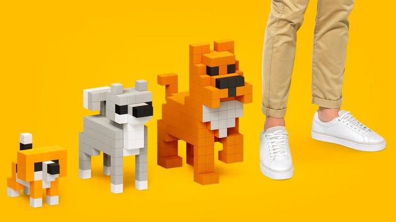 A person standing next to three dog sculptures built with the Voxart tiles.