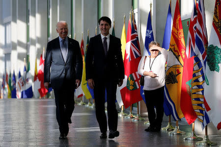 A woman watches as U.S. Vice President Joe Biden (L) and Canada's Prime Minister Justin Trudeau arrive at the First Ministers’ meeting in Ottawa, Ontario, Canada, December 9, 2016. REUTERS/Chris Wattie