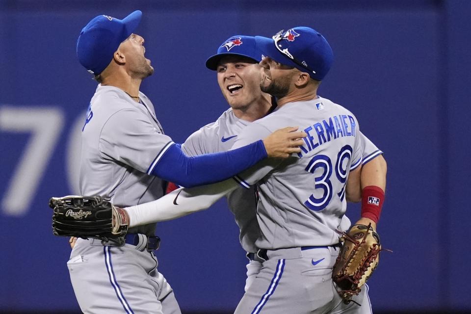 Toronto Blue Jays' George Springer, left, celebrates with Kevin Kiermaier, right, and Daulton Varsho after a baseball game against the New York Mets on Friday, June 2, 2023, in New York. The Blue Jays won 3-0. (AP Photo/Frank Franklin II)