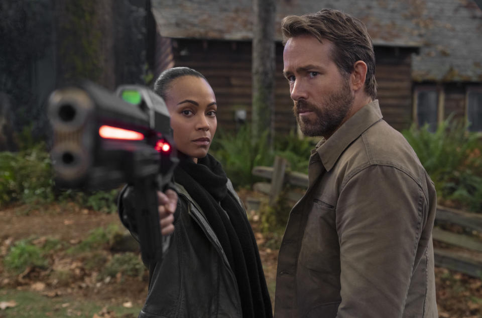 This image released by Netflix shows Zoe Saldana, left, and Ryan Reynolds in a scene from "The Adam Project." (Doane Gregory/Netflix via AP)