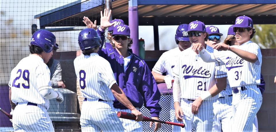 Wylie's Braden Regala (8) celebrates with teammates after scoring the game's first run on Landon Williams' single in the first inning against Lubbock Monterey. The Bulldogs beat Monterey 3-0 in the District 4-5A opener Tuesday, March 15, 2022, at Bulldog Field.