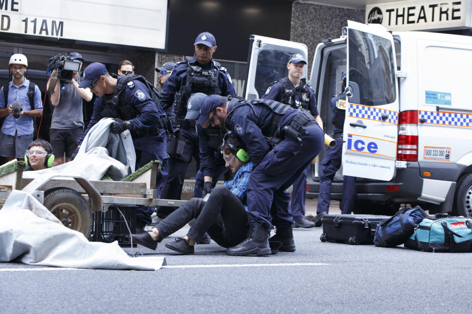 An Extinction Rebellion protester is placed under arrest by Queensland Police after being cut from a metal structure used to block the flow of traffic on George Street on Tuesday. Source: Joshua Prieto / SOPA Images/Sipa USA.