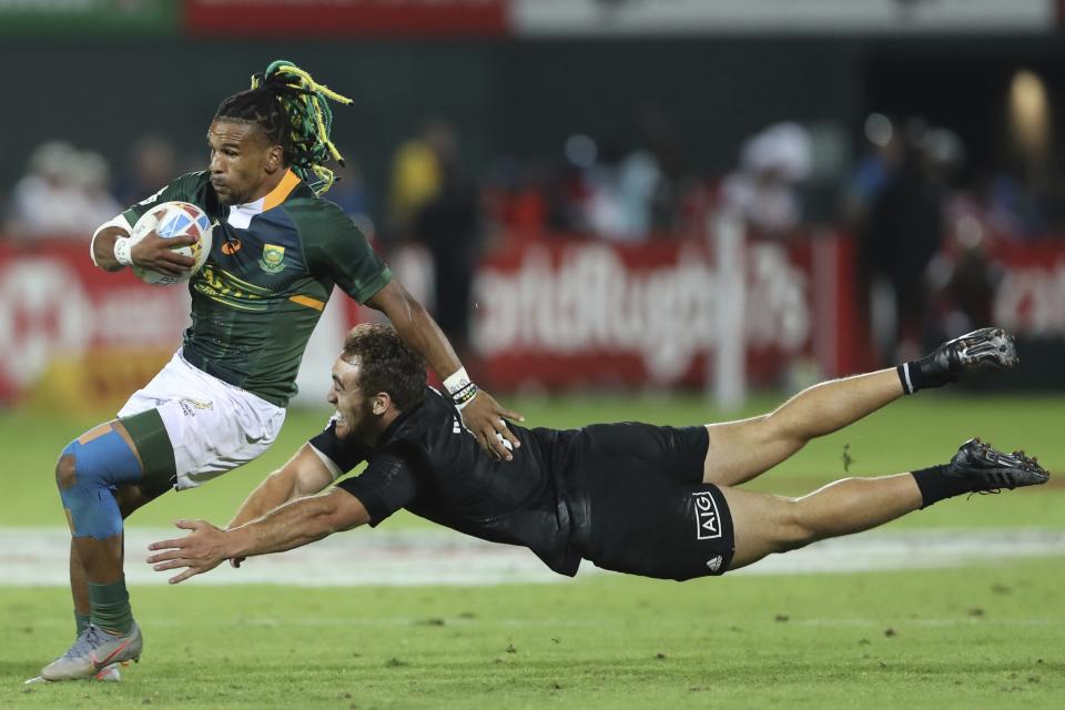 South Africa's Rosko Specman misses a tackle by New Zealand's player in the final match of the Emirates Airline Rugby Sevens in Dubai, United Arab Emirates, Saturday, Dec.7, 2019. (AP Photo/Kamran Jebreili)