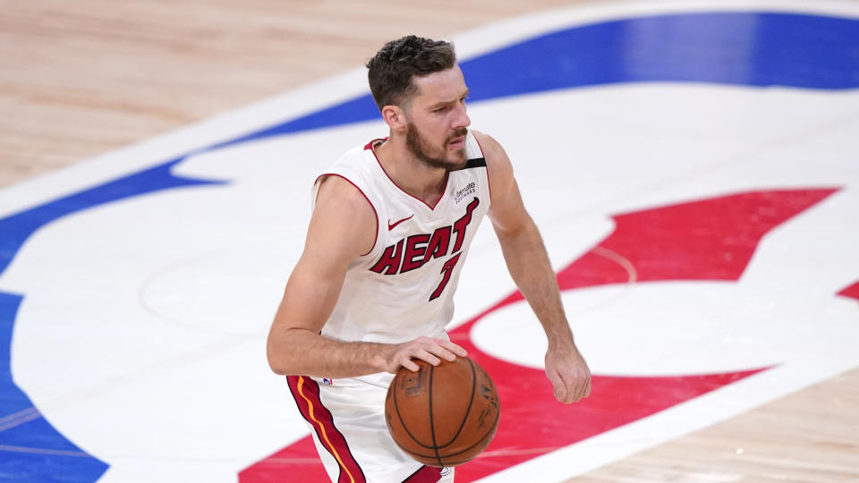 Goran Dragic in a white Heat jersey dribbles at midcourt. 