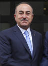 Turkey's Foreign Minister Mevlut Cavusoglu, left, poses for photographs prior to his meeting with North Macedonia's Foreign Minister Nikola Dimitrov, in Skopje, North Macedonia, Tuesday, July 16, 2019. Cavusoglu on Tuesday downplayed as "worthless" an initial set of sanctions approved by the European Union against Ankara and vowed to send a new vessel to the eastern Mediterranean to reinforce its efforts to drill for hydrocarbons off the island of Cyprus. EU foreign ministers on Monday approved sanctions against Turkey over its drilling for gas in waters where EU member Cyprus has exclusive economic rights. (Cem Ozdel/Turkish Foreign Ministry via AP, Pool)